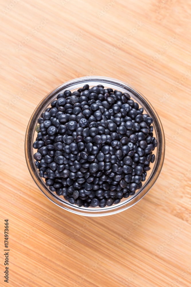 Black beluga lentils on a wood background Black beluga lentils on a wood background