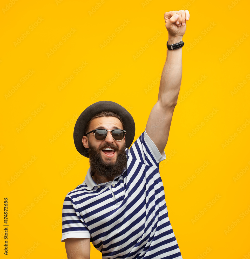 Naklejka premium Victorious hipster posing on orange
