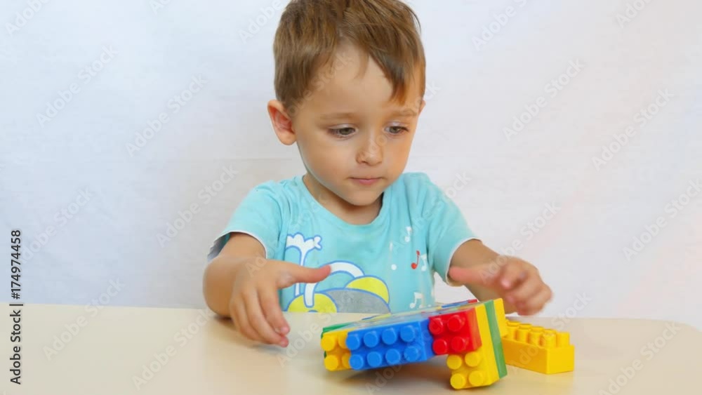 The child collects the tower from the colored blocks. The child collects the tower from the colored blocks.
