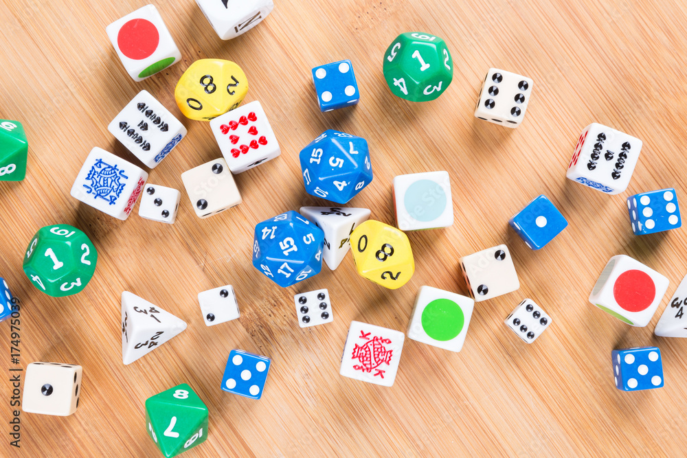 Assorted dice game pieces on a wood background Assorted dice game pieces on a wood background