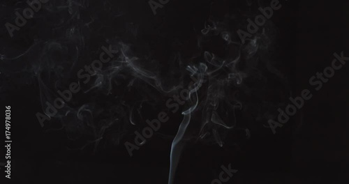 Wisps of white smoke swirling in the air on white background