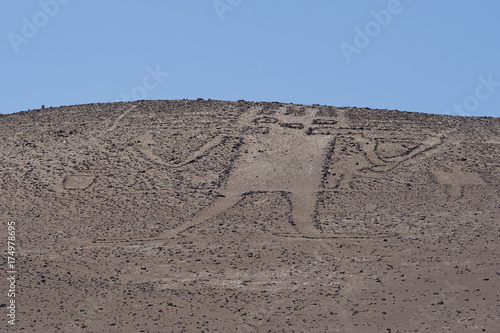 Giant of the Atacama. Large petroglyph on a rocky outcrop in the Atacama Desert in the Tarapaca Region of northern Chile.  photo