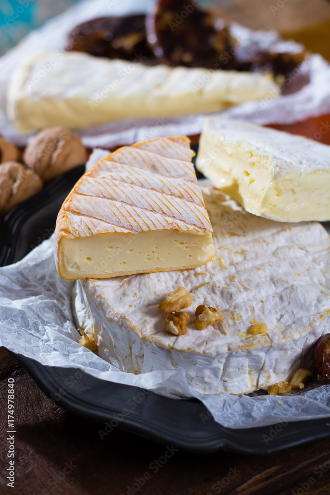 French soft cheeses - camembert, marcaire, munster, brie - delicious dessert with nuts and dried fruits
