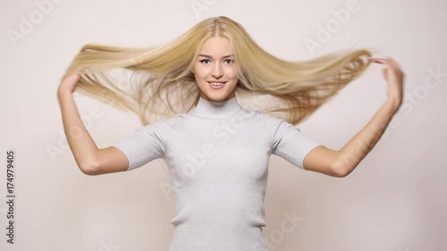 Woman  playing with blond long hair on white background