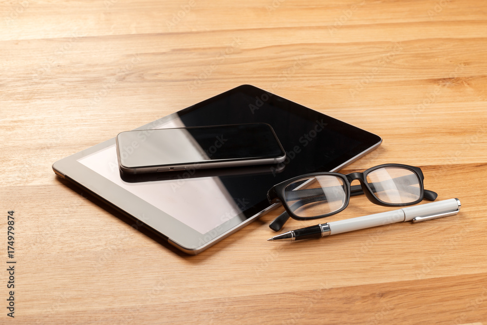 Smartphone and digital tablet on wooden desk Smartphone and digital tablet on wooden desk
