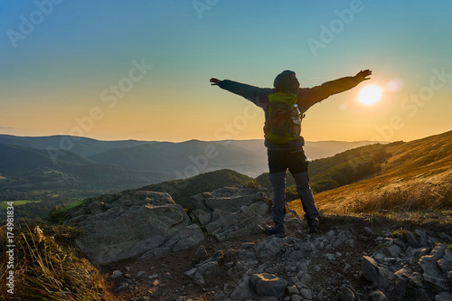 Fototapeta Naklejka Na Ścianę i Meble -  Freedom, man spreads his hands on the Sunset. Beautiful panoramic view of the Bieszczady mountains in the early autumn, Bieszczady National Park (Polish: Bieszczadzki Park Narodowy), Poland.