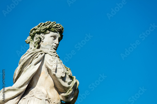 Classic statue in a park with blue sky on background