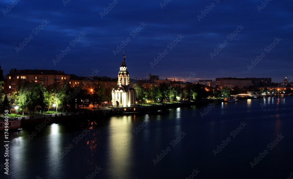 Beautiful church  with illuminating  at night, lights reflected in the water. View of the  Dnipropetrovsk Embankment  (Dnepr, Dnepropetrovsk, Dnipro). Ukraine