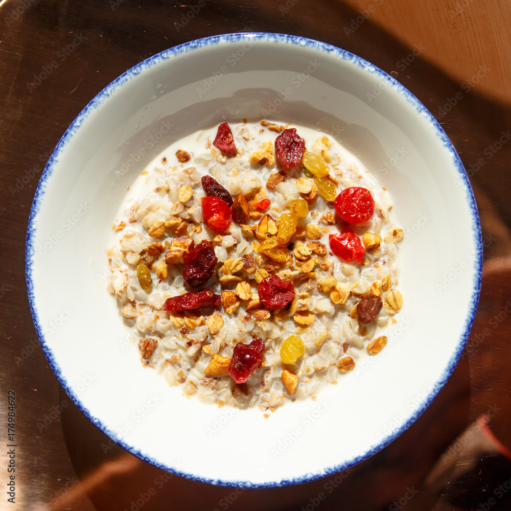 Oatmeal with granola and dried berries lying on the plate. Sunny morning, Breakfast Oatmeal with granola and dried berries lying on the plate. Sunny morning, Breakfast