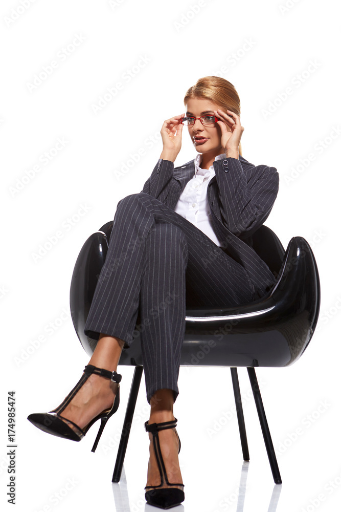 Blonde business woman sitting black chair isolated on white Blonde business woman sitting black chair isolated on white