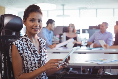 Fotografie Portrait of businesswoman using digital tablet in office