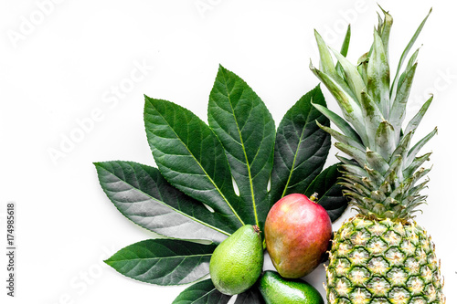 Tropical fruits background. Mango near exotic leaf and pineapple on white top view