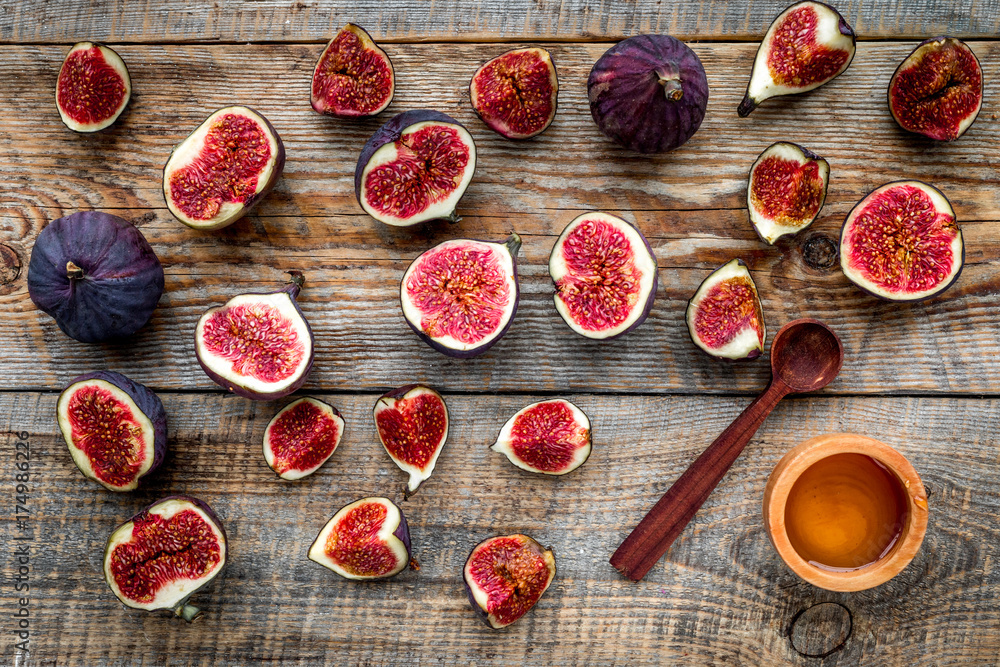 Fresh blue figs and honey on wooden background top view