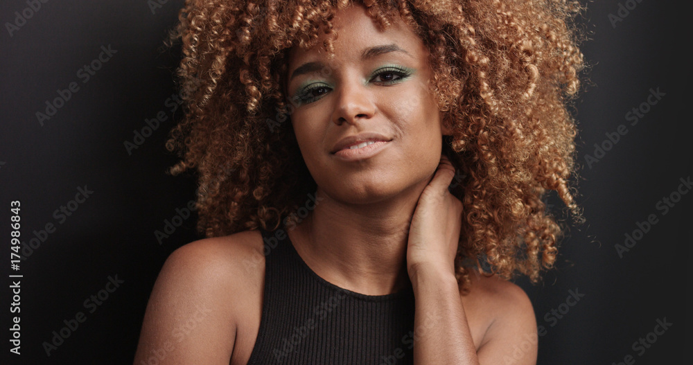 Fototapeta premium Pretty black girl with big hair posing video on black background