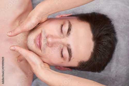 Face massage, handsome man. Hands of masseuse. Massage tips from professionals.