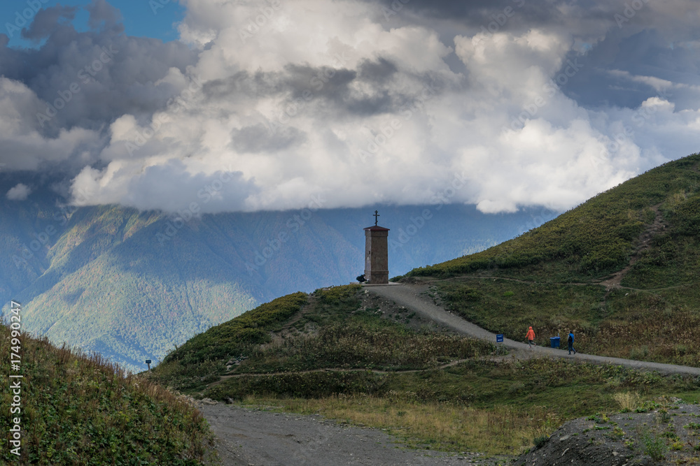 Christian monument on top of a mountain among the clouds and mountain vegetation