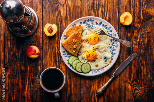 Breakfast toast with fried eggs with vegetables, coffee and frui