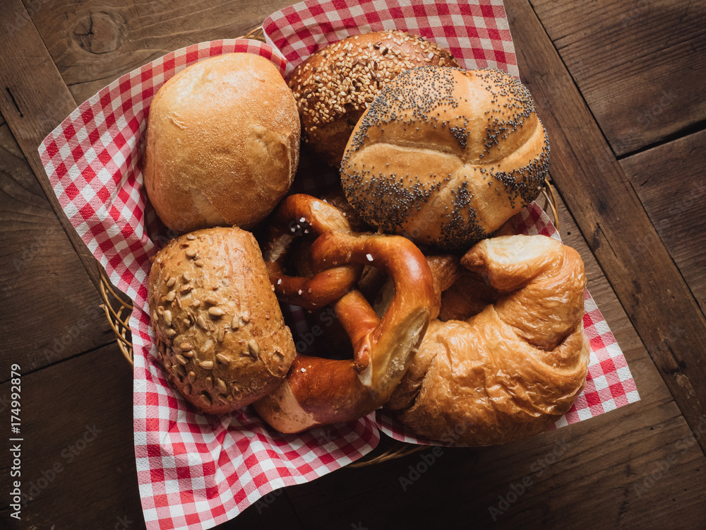 Brotkorb mit rot-weiß karierter Serviette auf Holzplatte gefüllt mit  traditionellen Deutschen Frühstücks-Brötchen, wie Mohn-Semmel,  Vollkornsemmel, Körner-Brötchen, Salz-Breze und Croissants Stock-Foto |  Adobe Stock