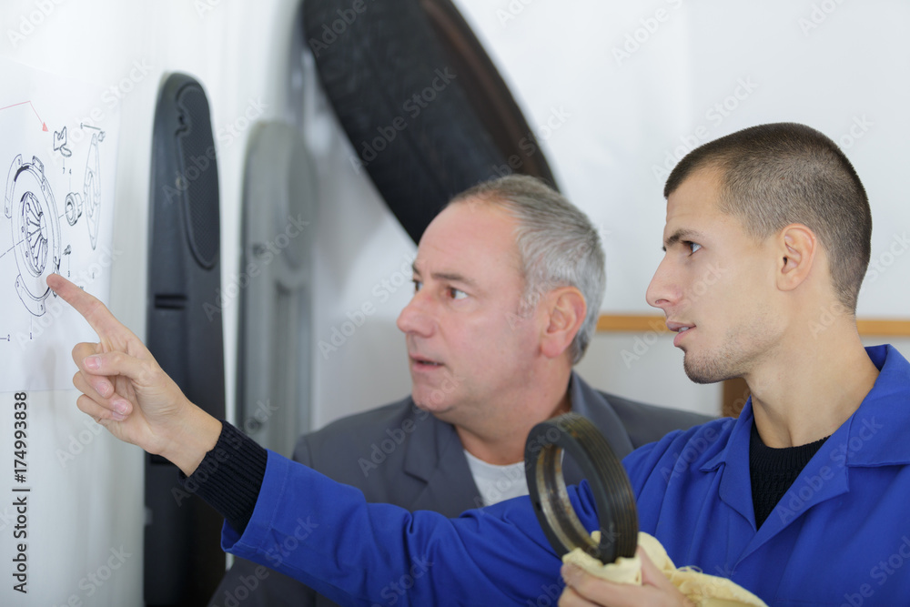 Obraz premium student with auto part and teacher in automotive school