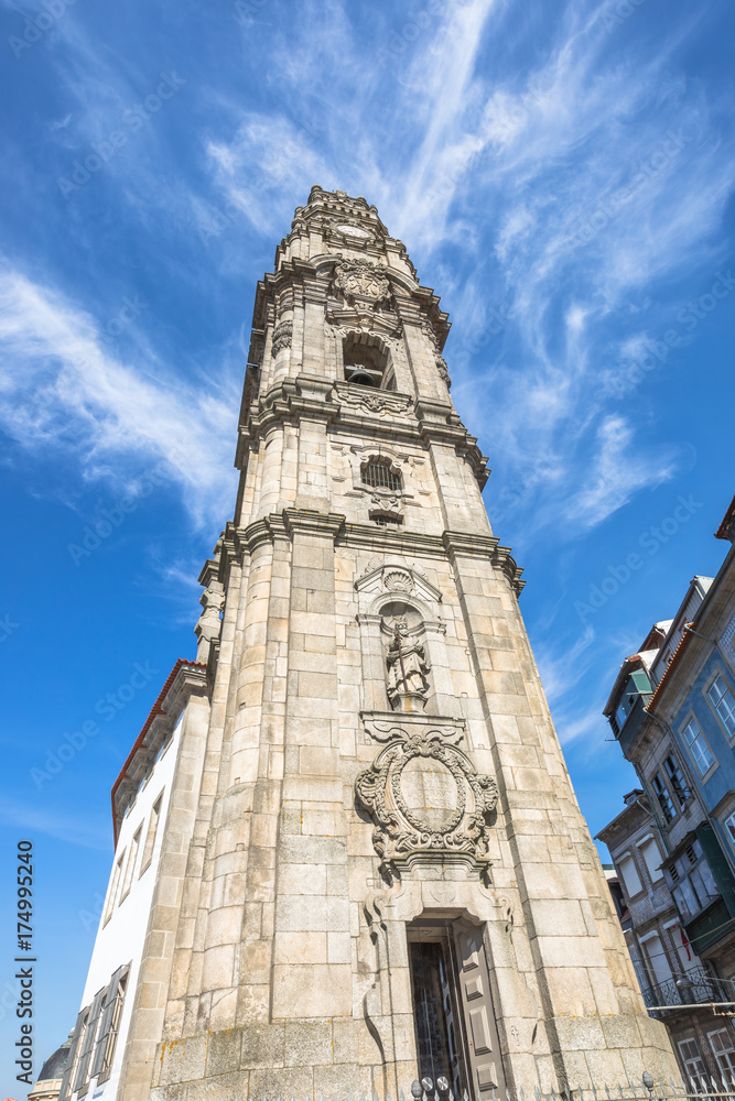 Prospective view of the iconic baroque Clerigos Tower, one of the landmarks and symbols of the city of Porto in Portugal. Sunny day in the blue sky.
