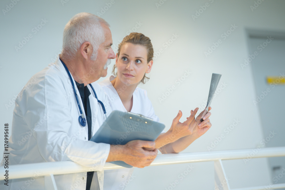 Medical staff in discussion leaning over balustrade