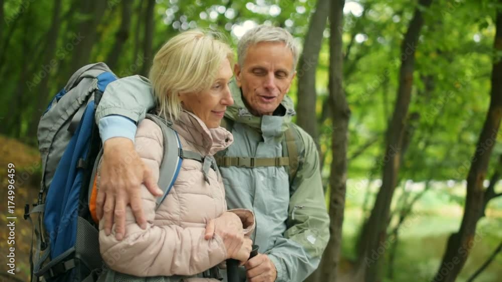 Positive aged couple enjoying active tourism in the forest Positive aged couple enjoying active tourism in the forest