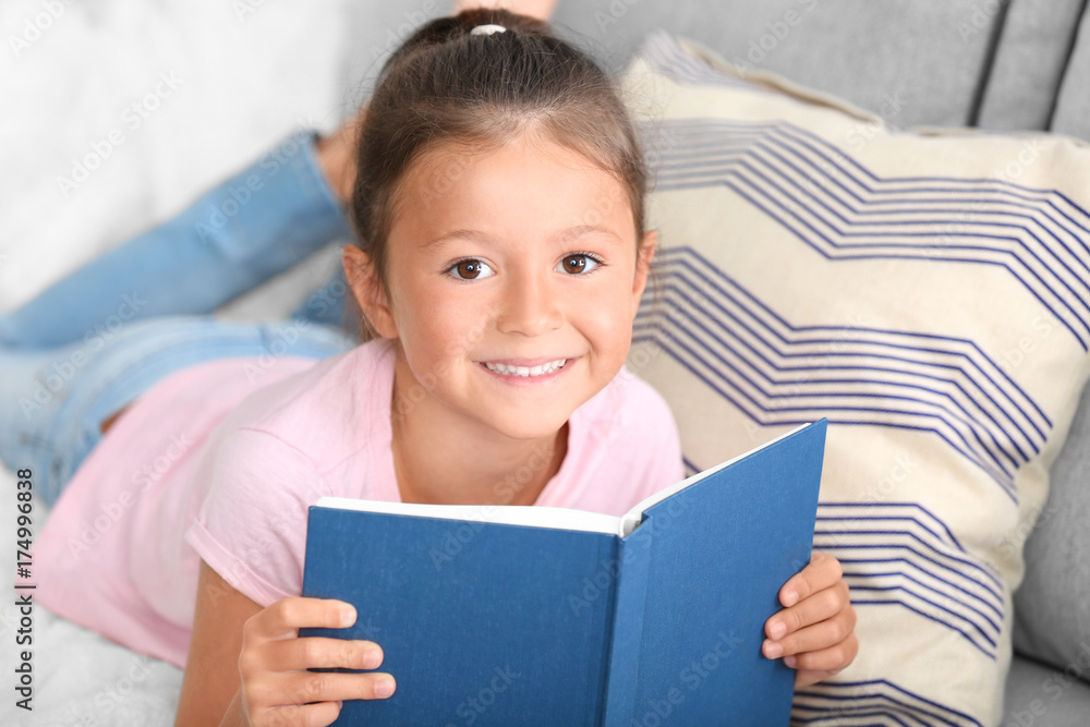 Cute little girl reading book at home Cute little girl reading book at home