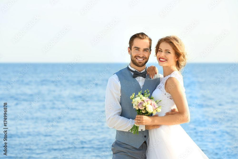 Happy wedding couple on sea beach