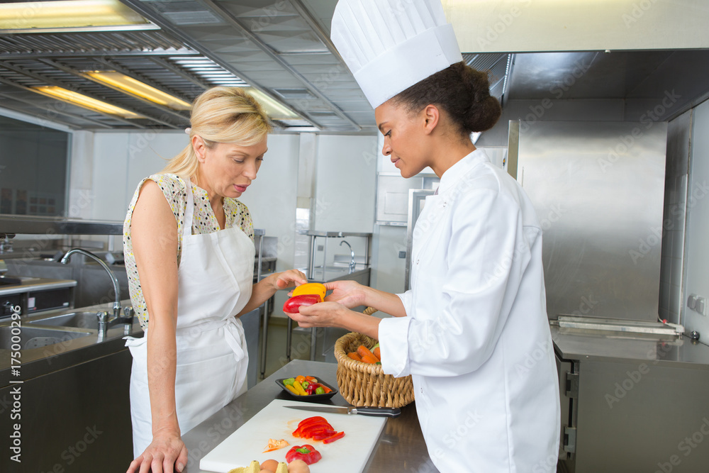 two female chefs working beside each other in hotel kitchen two female chefs working beside each other in hotel kitchen
