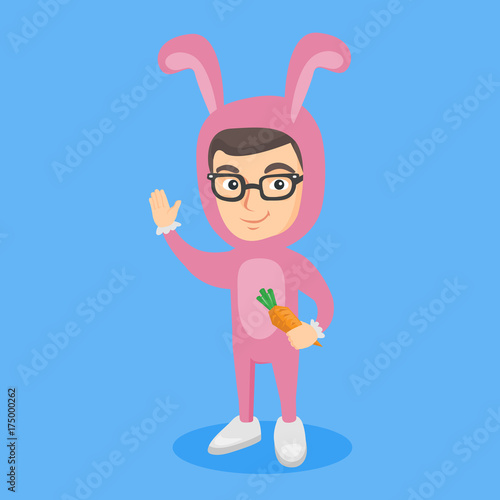Little caucasian boy wearing a rabbit costume and holding a carrot. Happy child dressed as a rabbit waving hand. Vector cartoon illustration. Square layout.