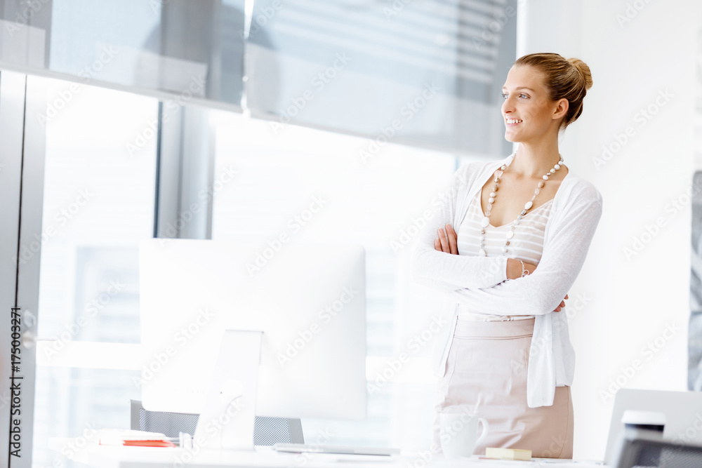 Attractive office worker standing next to window Attractive office worker standing next to window