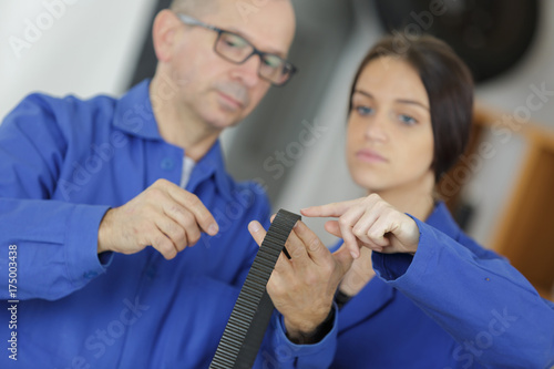 auto mechanic shows the female trainee maintenance of the car photo