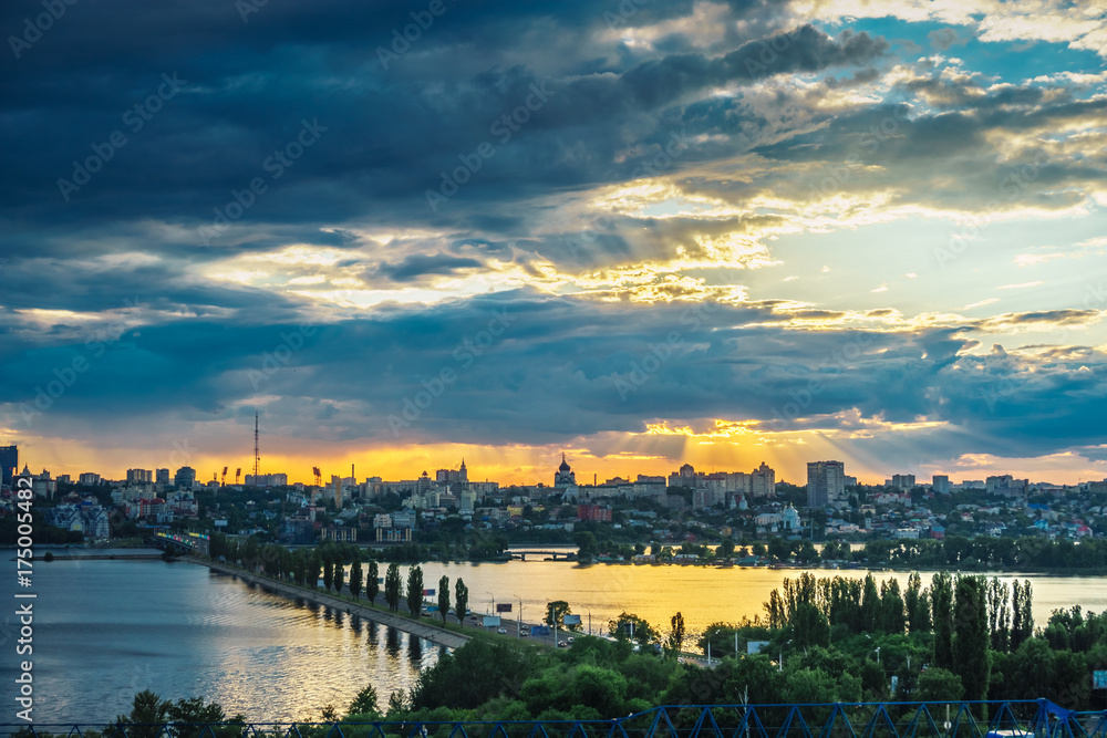 Dramatic sunset and dark clouds over right bank of Voronezh, Chernavsky bridge over water reservoir 