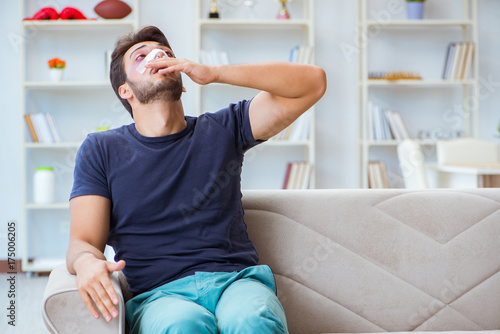 Young man recovering healing at home after plastic surgery nose  photo