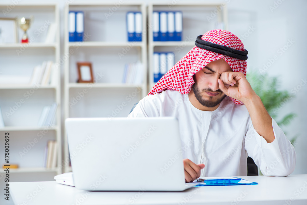 Arab businessman working in the office doing paperwork with a pi Arab businessman working in the office doing paperwork with a pi
