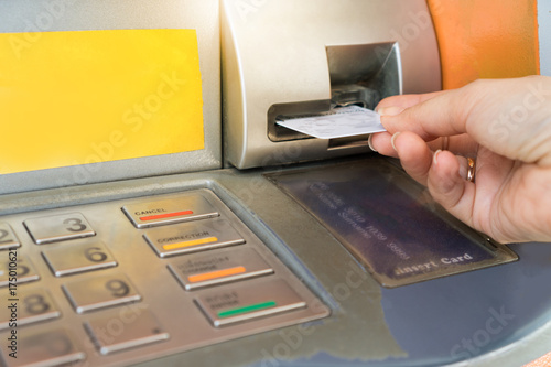 Hand inserting ATM card into bank machine.