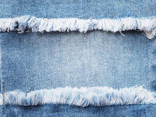 Edge frame of blue denim ripped over jeans texture background.