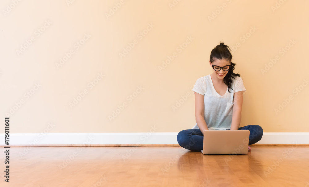 Young woman using her laptop in a big room Young woman using her laptop in a big room