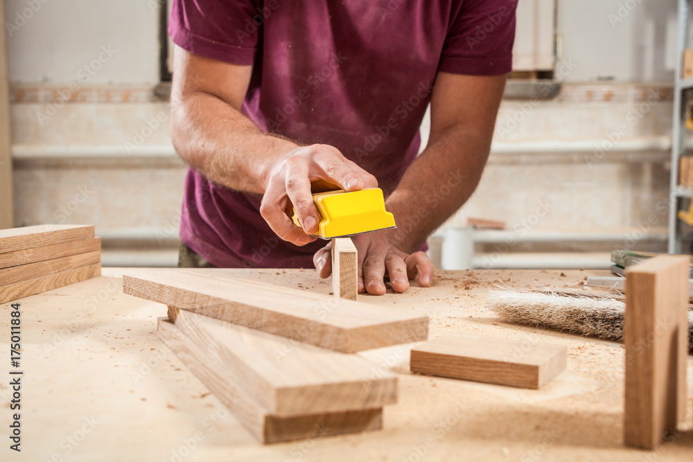 man sanding a wooden man sanding a wooden
