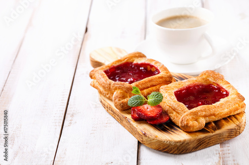 Berry pies and coffee in a cup on a white wooden background. Selective focus.