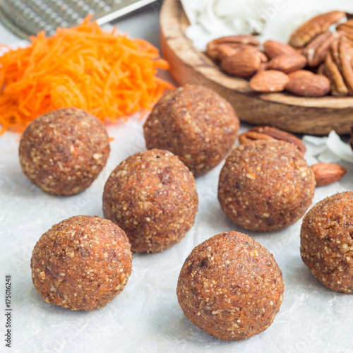 Healthy homemade paleo energy balls with carrot, nuts, dates and coconut flakes, on parchment, square format