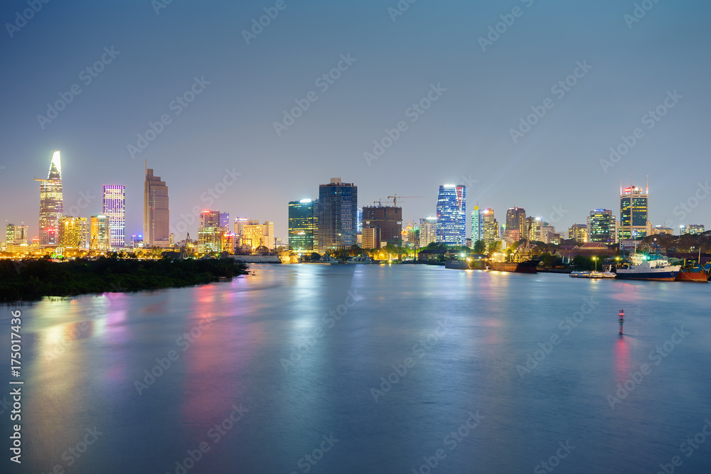 Fototapeta premium Night view of Business and Administrative Center of Ho Chi Minh city on Saigon riverbank in twilight, Vietnam. 