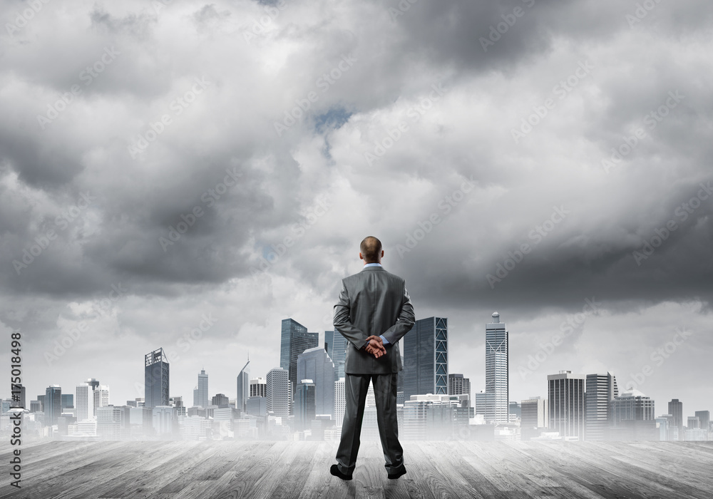 Motivation and inspiration concept with modern cityscape and businessman observing it Motivation and inspiration concept with modern cityscape and businessman observing it