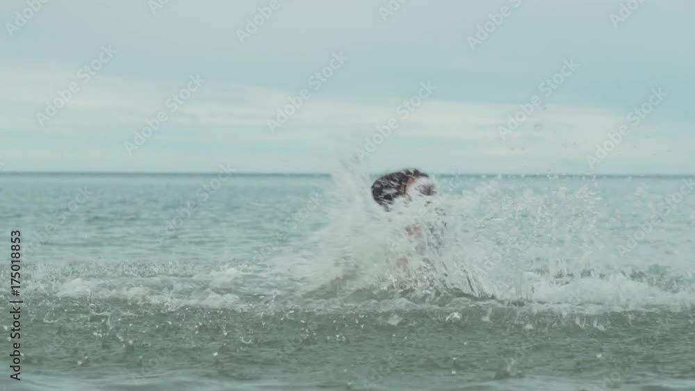 Joyful happy young girl playing with splashing water in sea slow motion stock footage video Joyful happy young girl playing with splashing water in sea slow motion stock footage video