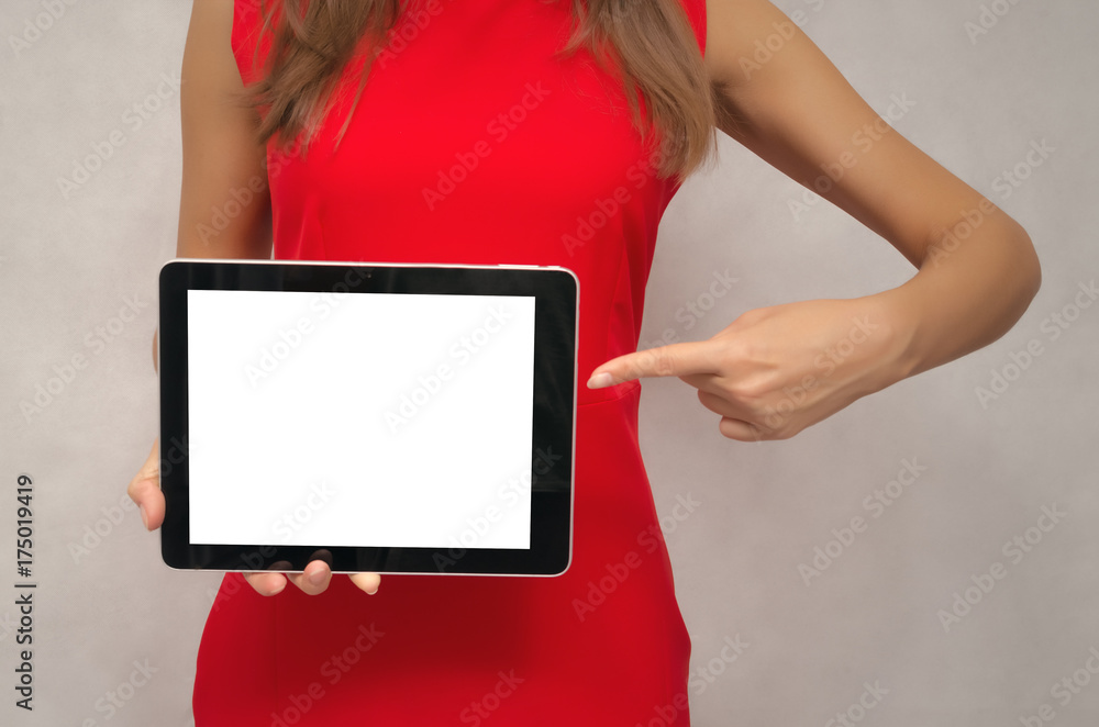 Φωτογραφία Young woman in red dress holding in hands tablet computer with blank screen and pointing on it by finger