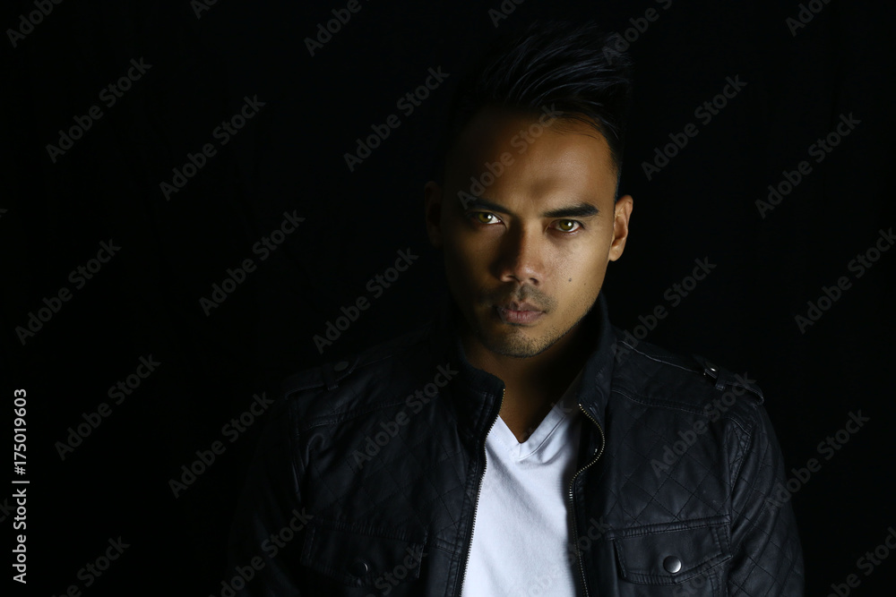 Fototapeta premium Young vampire before his transformation on a dark background 