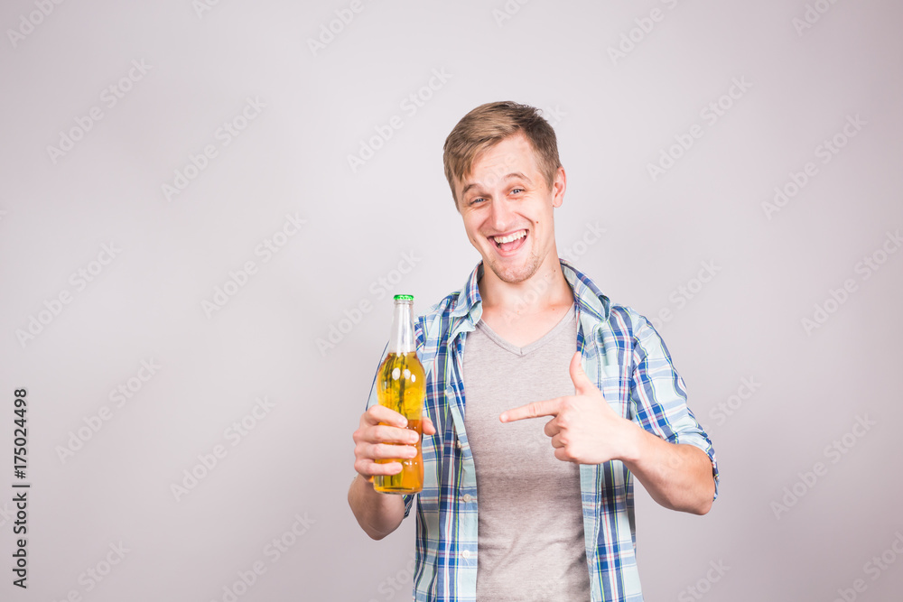 Handsome caucasian man holding a bottle of beer. Background with copy space Handsome caucasian man holding a bottle of beer. Background with copy space