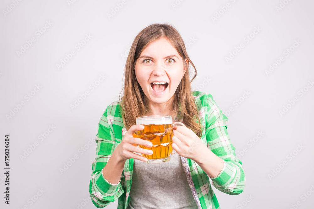 Portrait an euphoric sports fan holding mug of beer. Woman with beer Portrait an euphoric sports fan holding mug of beer. Woman with beer