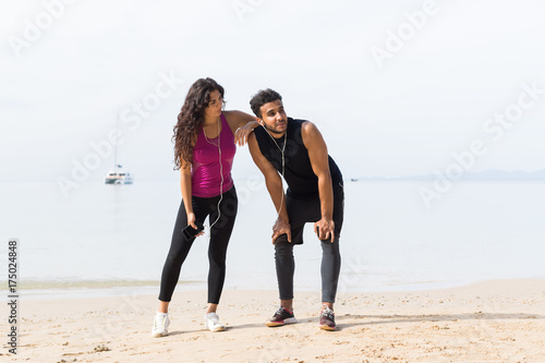 Couple Of Runner Having Rest After Training On Beach Man And Woman Sport Runners Standing Fit Male And Female Fitness Jogger On Seaside Together