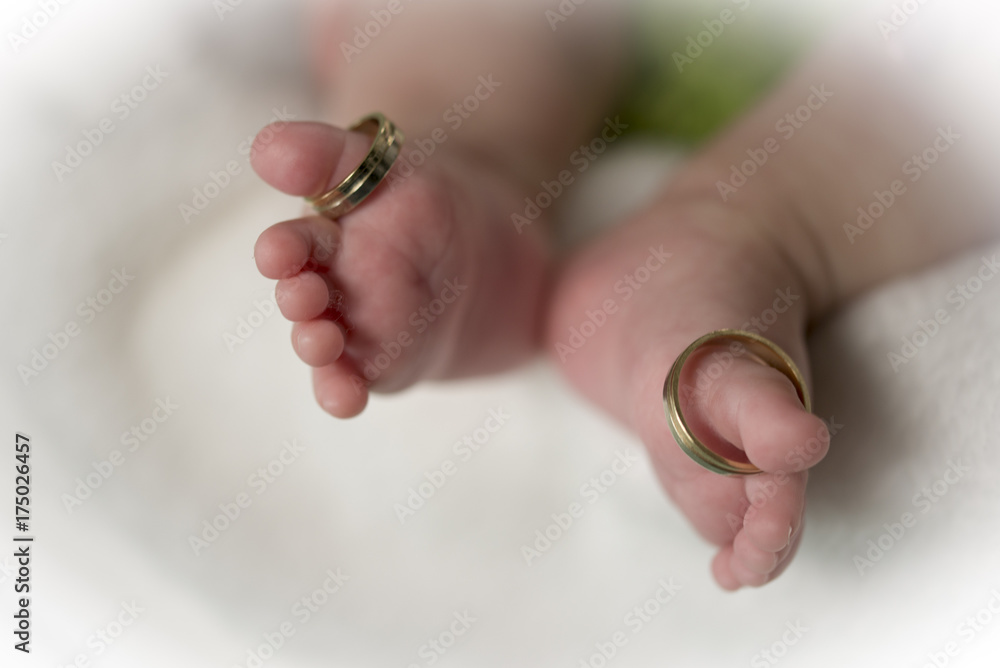 Beautiful conceptual image of feet weeding rings put on baby feet fingers Beautiful conceptual image of feet weeding rings put on baby feet fingers